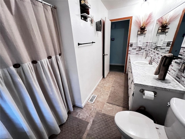 bathroom with vanity, a textured ceiling, backsplash, and toilet