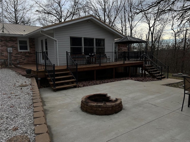 back of property with a patio area, an outdoor fire pit, and a wooden deck