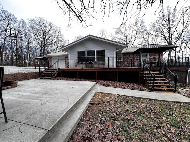 back of property featuring a patio and a wooden deck