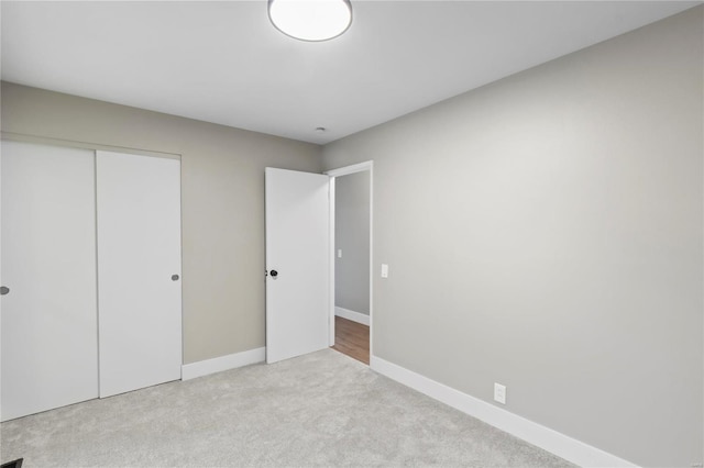 unfurnished bedroom featuring light carpet and a closet