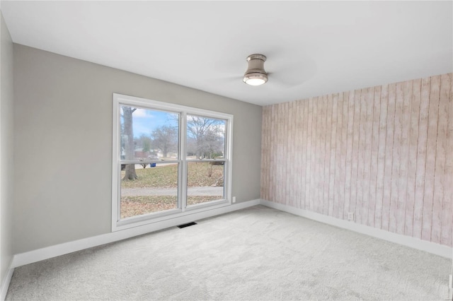 carpeted spare room with ceiling fan