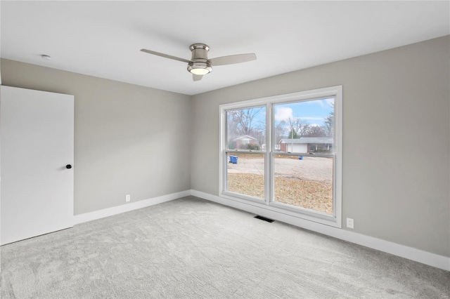 carpeted spare room with ceiling fan