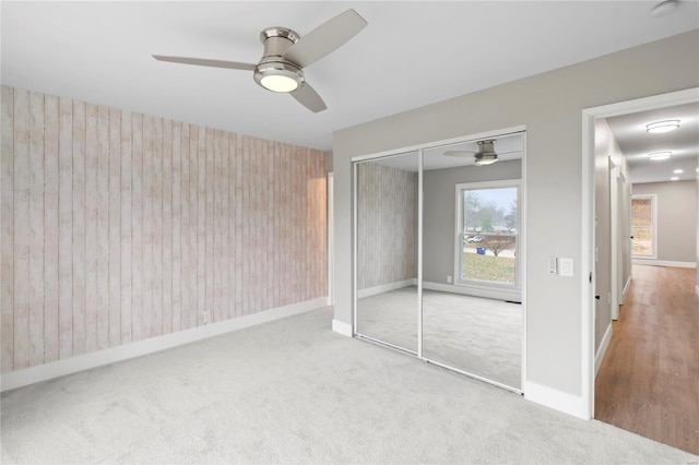 unfurnished bedroom with carpet flooring, a closet, and ceiling fan