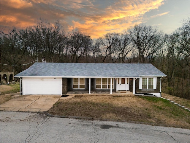 ranch-style home with a garage and a yard