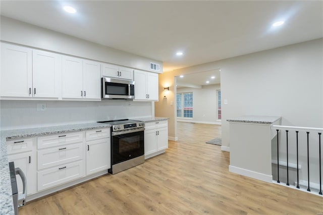 kitchen featuring light stone countertops, stainless steel appliances, white cabinetry, and light hardwood / wood-style floors