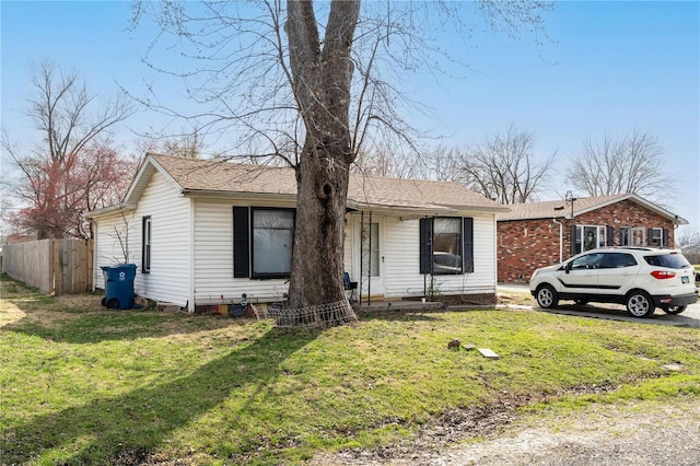 single story home with a front yard and fence