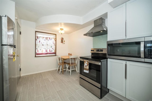 kitchen with white cabinets, decorative backsplash, wall chimney range hood, and stainless steel appliances