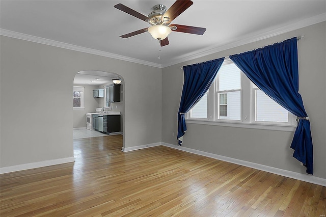 spare room with ceiling fan, crown molding, and light hardwood / wood-style flooring