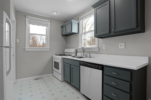 kitchen with gray cabinetry, sink, and white appliances