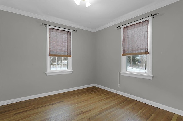 empty room featuring crown molding, a wealth of natural light, and light hardwood / wood-style flooring