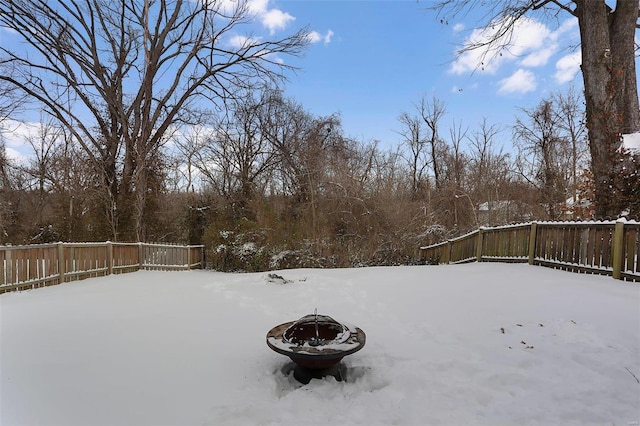 yard covered in snow with an outdoor fire pit