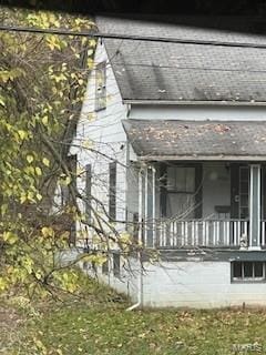 view of side of property featuring covered porch