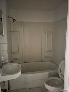 bathroom featuring tile patterned floors, bathing tub / shower combination, and toilet