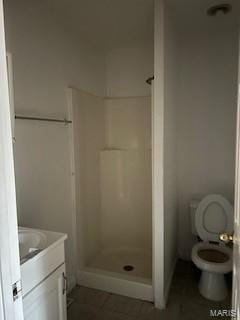 bathroom featuring a shower, vanity, and toilet