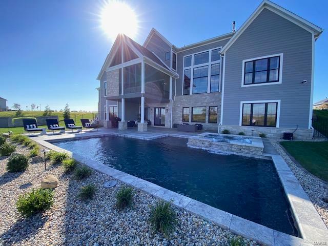 back of property featuring a patio, a lawn, and a sunroom