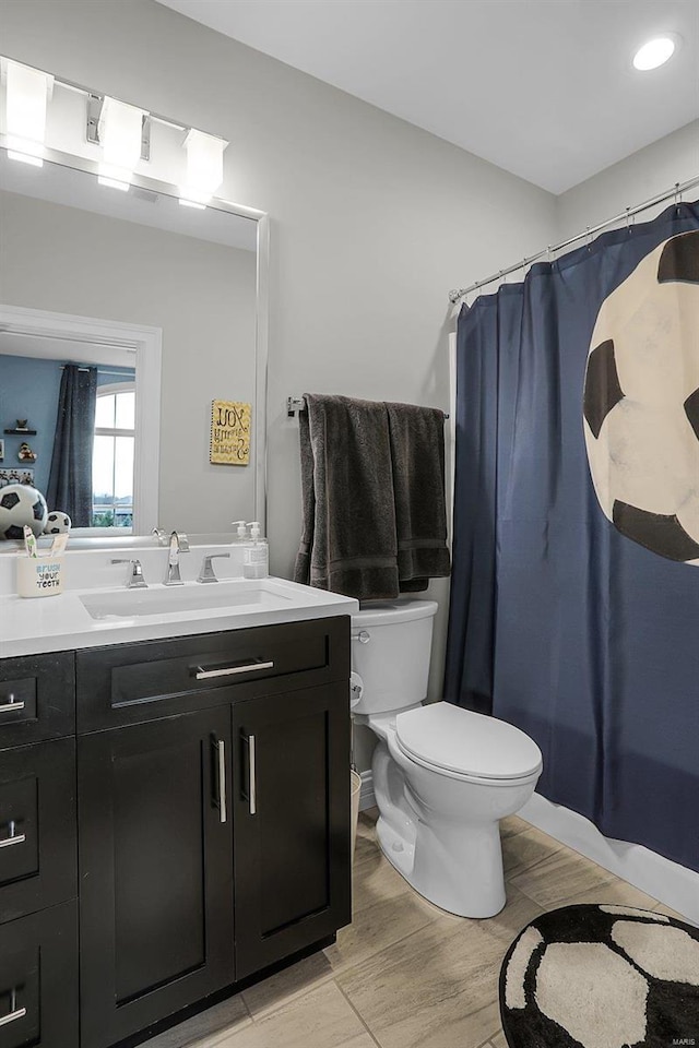 bathroom featuring vanity, hardwood / wood-style flooring, and toilet