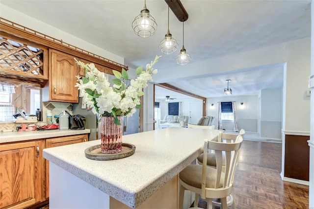 kitchen with decorative light fixtures, tasteful backsplash, ceiling fan, dark parquet floors, and a kitchen breakfast bar