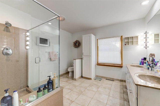 bathroom featuring vanity, tile patterned floors, a shower with shower door, and toilet