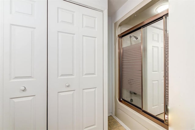 bathroom with shower / bath combination with glass door