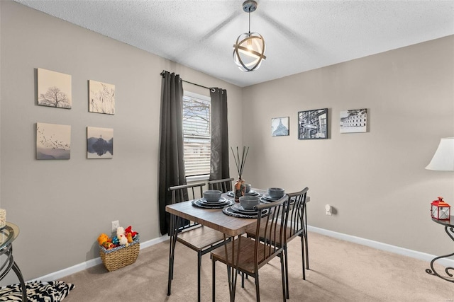 carpeted dining room with a textured ceiling