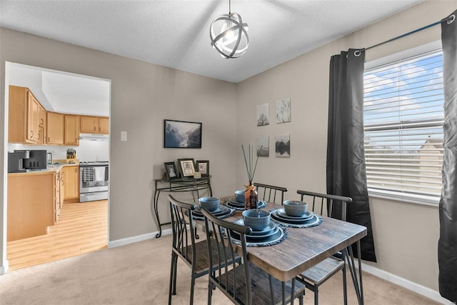 dining space with light carpet and a textured ceiling