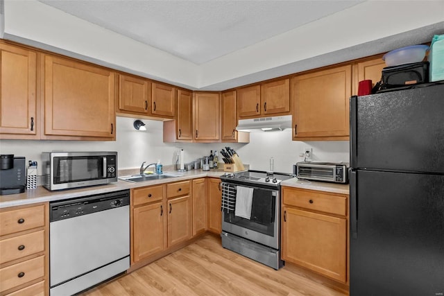 kitchen with sink, light wood-type flooring, and appliances with stainless steel finishes