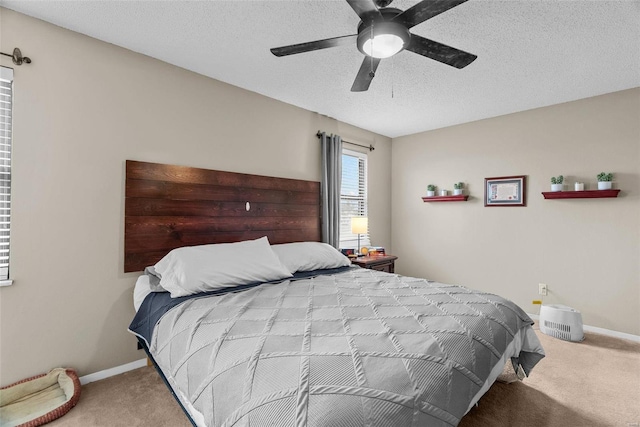 carpeted bedroom with ceiling fan and a textured ceiling