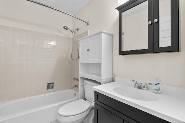 full bathroom with toilet, vanity, a textured ceiling, and tiled shower / bath