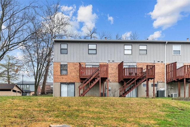 back of property featuring a lawn, central AC unit, and a wooden deck