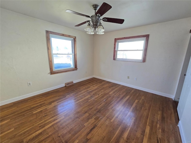 empty room with ceiling fan, dark hardwood / wood-style flooring, and a healthy amount of sunlight