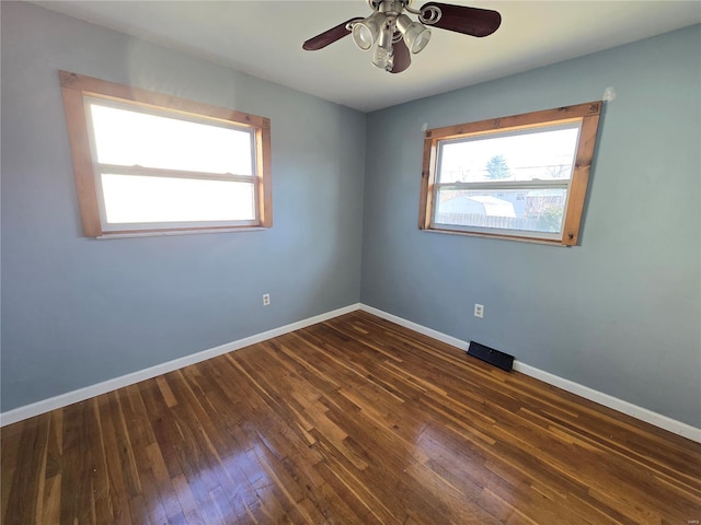 empty room with ceiling fan and dark hardwood / wood-style flooring