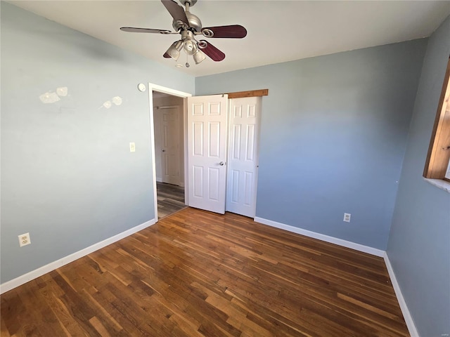 unfurnished bedroom with ceiling fan and dark hardwood / wood-style flooring