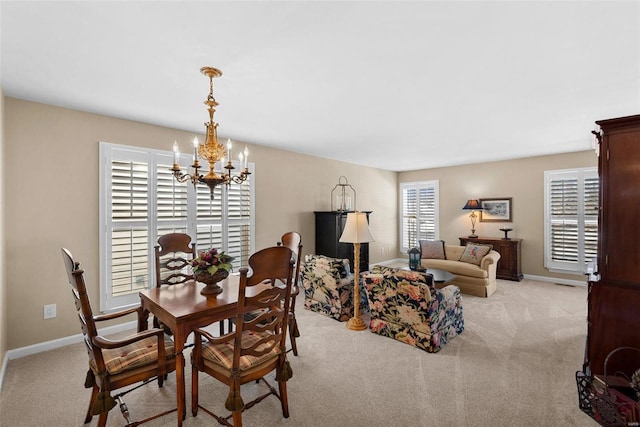 dining area featuring light colored carpet and a chandelier