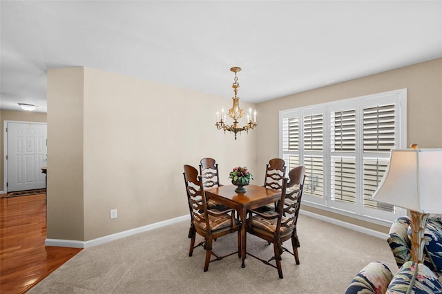 carpeted dining room with a notable chandelier