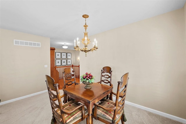 dining area with light colored carpet and a chandelier