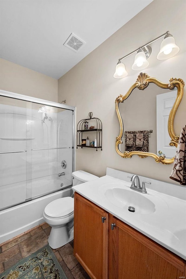 full bathroom featuring toilet, bath / shower combo with glass door, and vanity