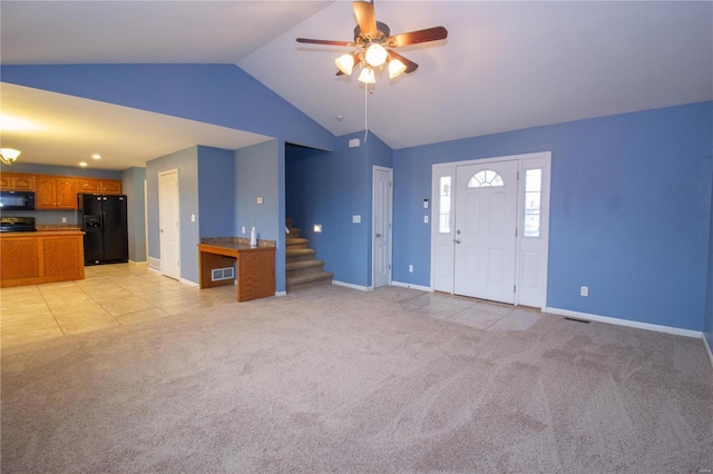 unfurnished living room with ceiling fan, light colored carpet, and lofted ceiling