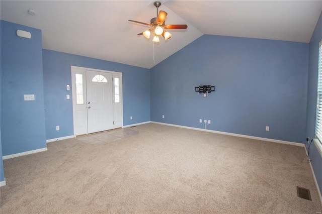 interior space featuring ceiling fan, vaulted ceiling, and light carpet