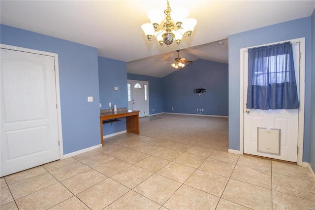 interior space featuring ceiling fan with notable chandelier, vaulted ceiling, and light tile patterned floors