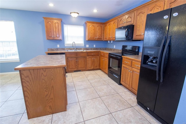 kitchen with a healthy amount of sunlight, a center island, sink, and black appliances