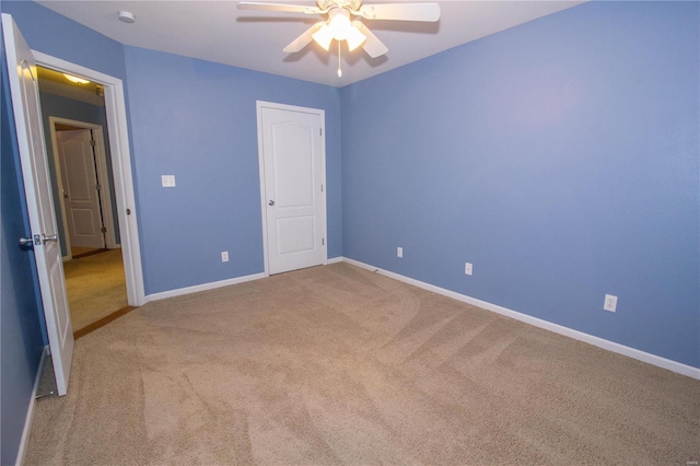 unfurnished bedroom featuring ceiling fan and light colored carpet