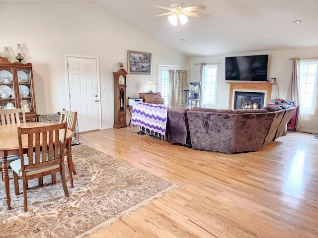 living room with high vaulted ceiling, light hardwood / wood-style flooring, a wealth of natural light, and ceiling fan