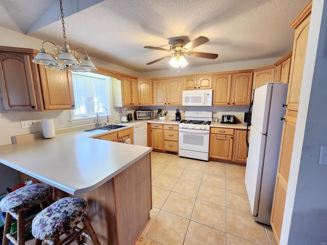 kitchen with white appliances, sink, decorative light fixtures, light tile patterned flooring, and kitchen peninsula