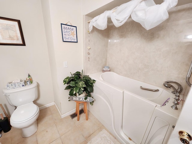 bathroom with a tub, tile patterned flooring, and toilet