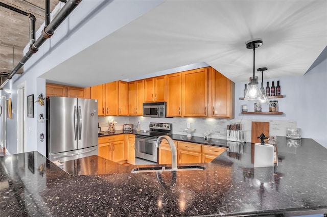 kitchen with decorative backsplash, pendant lighting, stainless steel appliances, and sink