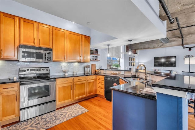 kitchen featuring pendant lighting, sink, light wood-type flooring, kitchen peninsula, and stainless steel appliances