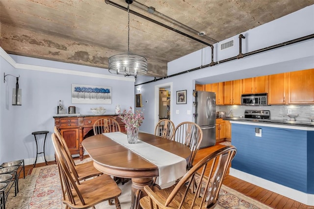 dining area featuring light wood-type flooring and a chandelier