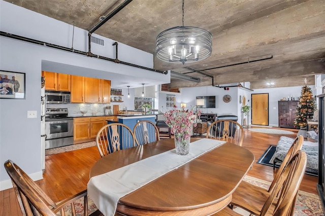 dining space with light wood-type flooring and a chandelier