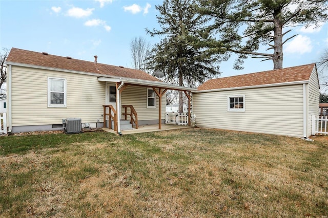 rear view of property featuring a yard, central AC, and an outdoor structure