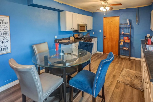 dining area featuring hardwood / wood-style flooring and ceiling fan